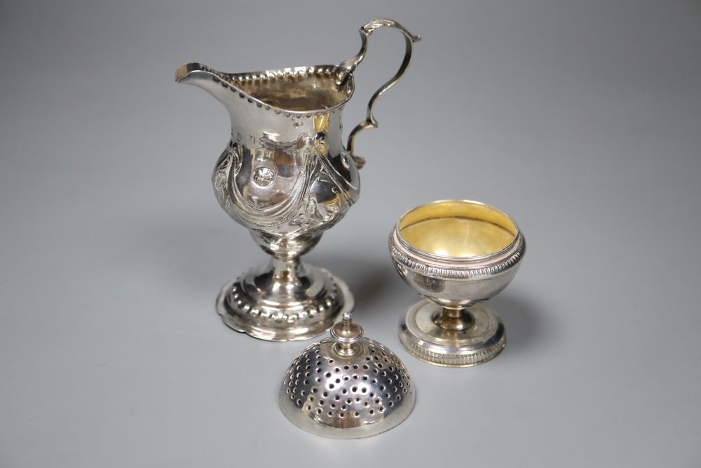 A George III silver inverted pear shaped cream jug, London, 1779 and a George III silver globe shaped pedestal pepperette